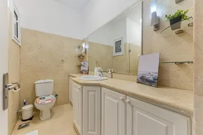 a bathroom with a sink and a toilet and a mirror at Modern 2 bedroom apartment in El Gouna with pool in Hurghada