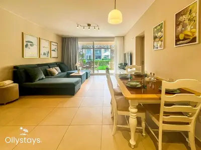 a living room with a table and a couch at Ollystays Mangroovy Seaview 1BR Beach and Pool Free access in Hurghada