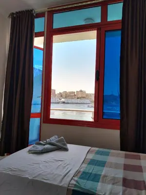 a bedroom with a window looking out at the ocean at New El Amin Guesthouse in Aswan