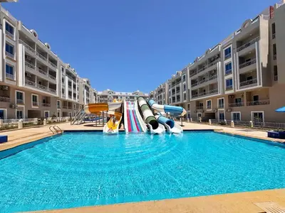 a pool with a slide in a apartment complex at Hurghada HUB Resort in Hurghada