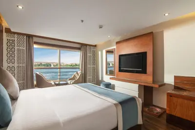 a hotel room with a large bed and a television at 4 nighhts luxury Nile cruise from Luxor to Aswan in Qena