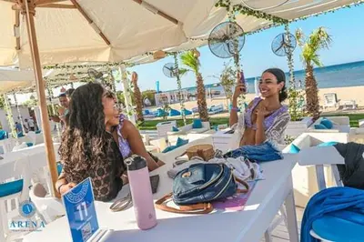 two women sitting at a table at a beach at SELENA BAY Luxury Suite beach front hurghada Arena Bar & restaurant سويت فاخر سيلينا باى in Hurghada