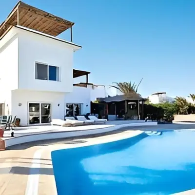 a villa with a swimming pool in front of a house at Coral Blue 'An expansive spacious 4 bedroom villa in El Gouna' in Hurghada