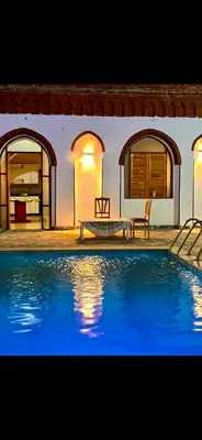 a large swimming pool in front of a house at Paradise Apartments in Al Aqālitah
