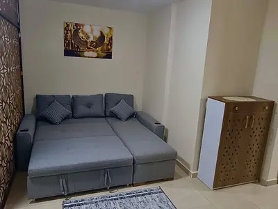 a small blue couch in a room with a table at Hurghada Studio Tiba Golden Resort in Hurghada
