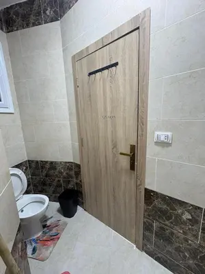 a wooden door in a bathroom with a toilet at La Prestigia chalet in Hurghada