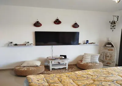 a living room with a couch and a tv on a wall at Studio at G Cribs B21-F10 El Gouna in Hurghada