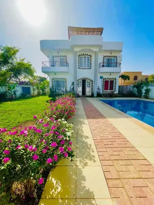 a house with a swimming pool and flowers at Luxor in Al Karnak