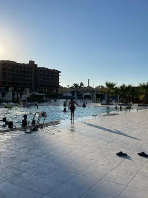 a person standing in the water at a swimming pool at CHALET IN HURGHADA SCANDIC ReSORT in Hurghada