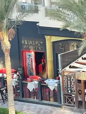 a palm tree in front of a restaurant at CHALET IN HURGHADA SCANDIC ReSORT in Hurghada