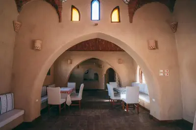 a dining room with an archway with tables and chairs at Sultana Palace in ‘Ezbet Abu Ḥabashi