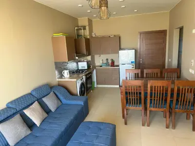 a living room with a blue couch and a kitchen at Luxury Escape in Hurghada, Egypt in Hurghada