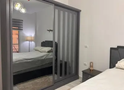 a bedroom with a mirrored closet with a bed in it at Desert Pearl luxury apartment in Hurghada