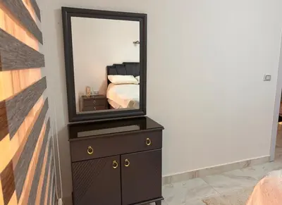 a bedroom with a dresser with a mirror on it at Desert Pearl luxury apartment in Hurghada
