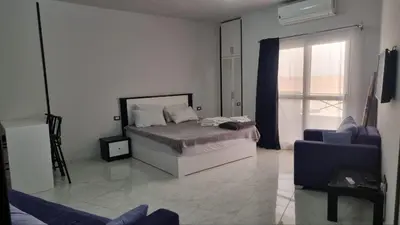 a bedroom with a bed and a window and a couch at Sunny Studio Tiba View Red Sea in Hurghada