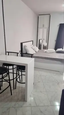 a white room with a bed and a table and chairs at Sunny Studio Tiba View Red Sea in Hurghada