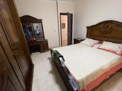 a bedroom with a large bed with a wooden headboard at Elhlal luxury apartment in Hurghada