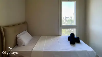 a bed with a teddy bear sitting on it next to a window at Ollystays Mangrovy Seaview Penthouse 3BR Beach & Pool access in Hurghada