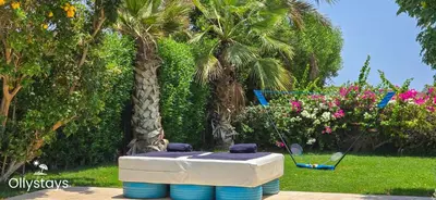 a hot tub sitting in a yard with palm trees at Ollystays Seaview Villa 3BR Heated Pool GYM-Joubal El Gouna in Hurghada