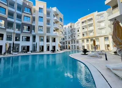 a swimming pool in front of some apartment buildings at Aqua Infinity in Hurghada