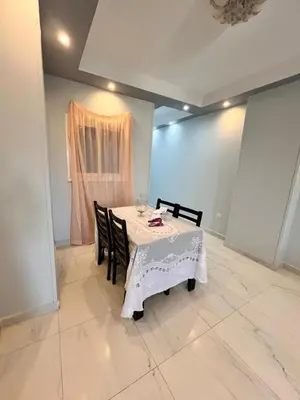 a dining room with a table and chairs and a window at Hurghada Promenade Spacious 1-Bedroom Apartment in Makramia Compound in Hurghada