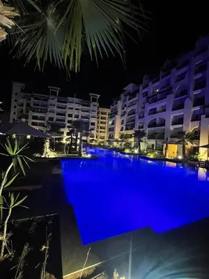 a large blue swimming pool in front of a building at Casa bonita in Hurghada
