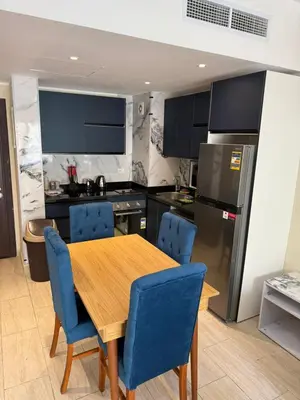 a kitchen with a wooden table and blue chairs at Casa bonita in Hurghada