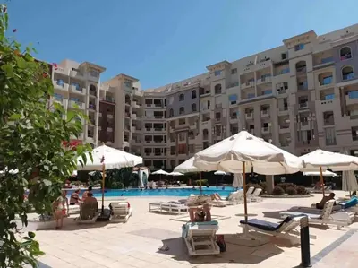 a hotel with a pool and chairs and umbrellas at Hurgada Florenza kamsen with pool view in Arabia area in Hurghada