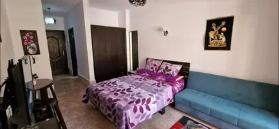 a bedroom with a purple bed and a couch at Hurgada Florenza kamsen with pool view in Arabia area in Hurghada