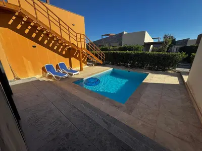 a patio with two chairs and a swimming pool at Private Somabay Villa with Pool in Hurghada