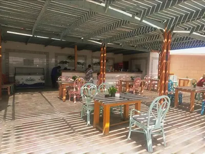 a restaurant with wooden tables and chairs in a room at Hurgada Princess resort on Mamsha with private beach&pools in Hurghada
