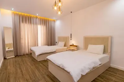 a bedroom with two beds and a chandelier at Private Villa AL Mamsha With Private Pool in Hurghada