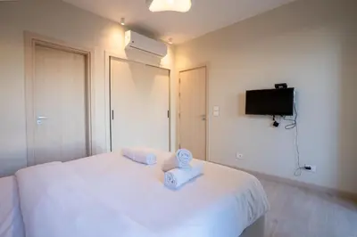 a bedroom with a white bed with two towels on it at Shedwan 2BR • Exquisite Ground Floor in Hurghada