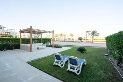 two chairs sitting on the grass in a yard at Shedwan 2BR • Exquisite Ground Floor in Hurghada