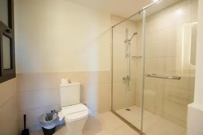 a bathroom with a toilet and a glass shower at Shedwan 2BR • Exquisite Ground Floor in Hurghada
