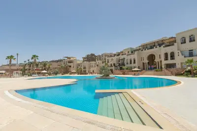 a swimming pool in a resort with buildings in the background at Cozy 1 bedroom Apartment in Azzurra Sahl Hasheesh in Hurghada