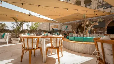 a restaurant with a table and chairs and a bar at Cozy 1 bedroom Apartment in Azzurra Sahl Hasheesh in Hurghada