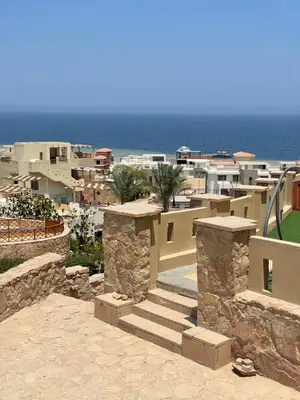 a view of a resort with the ocean and buildings at Cozy 1 bedroom Apartment in Azzurra Sahl Hasheesh in Hurghada