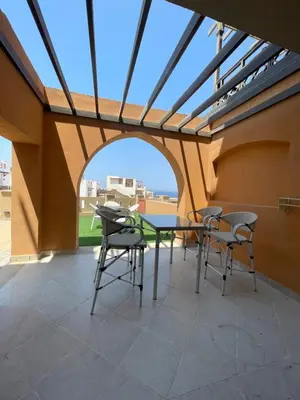 a patio with a table and chairs on a roof at Spacious sea view ,1 bedroom apartment in Azzurra Sahl Hasheesh in Hurghada