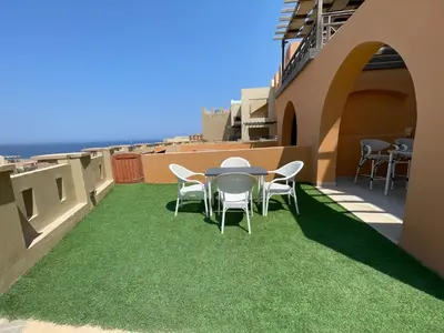a patio with a table and chairs on a balcony at Spacious sea view ,1 bedroom apartment in Azzurra Sahl Hasheesh in Hurghada