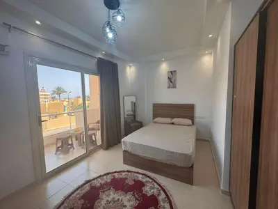a bedroom with a bed and a balcony at Florenza Khamasin C105 in Hurghada