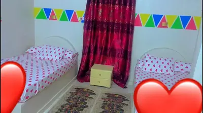 two twin beds in a room with red hearts at Wateen guest house in Aswan