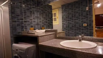 a bathroom with a sink and a washing machine at Alisra Hurghada Building in Hurghada
