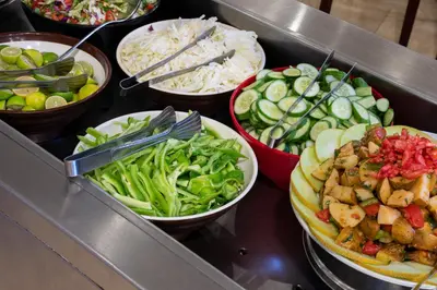 a buffet line with bowls of different types of food at Roma Hotel in Hurghada