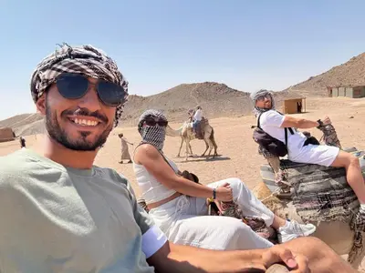 a group of people riding camels in the desert at Sun of Aswan Stay in Aswan