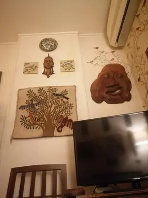 a room with paintings on the wall and a tv at Sun of Aswan Stay in Aswan