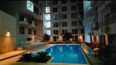 a swimming pool in front of a building at night at Nesim hights compound in Hurghada