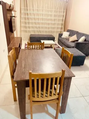 a wooden table and chairs in a living room at Nesim hights compound in Hurghada