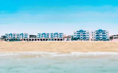 a view of a beach with buildings in the background at isis MARINA in Hurghada