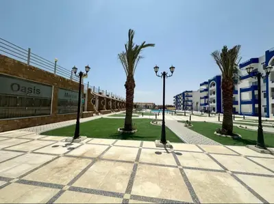a street with palm trees and lights on a sidewalk at isis MARINA in Hurghada